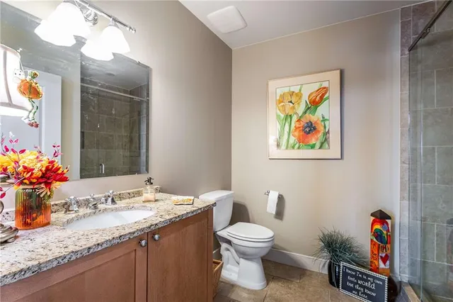 a bathroom with a granite countertop sink mirror vanity and toilet