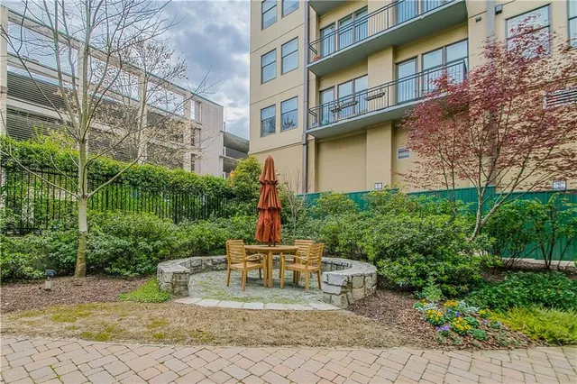 a view of a backyard with plants and brick walls