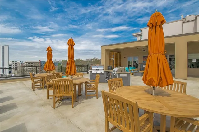 a view of a patio with couches and table and chairs and potted plants