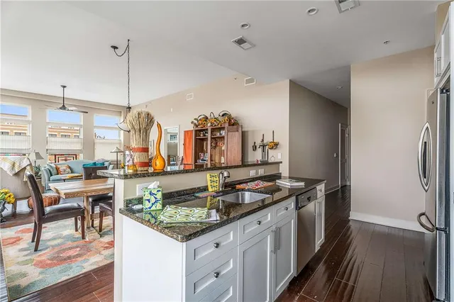 a kitchen with stainless steel appliances granite countertop a sink and a refrigerator