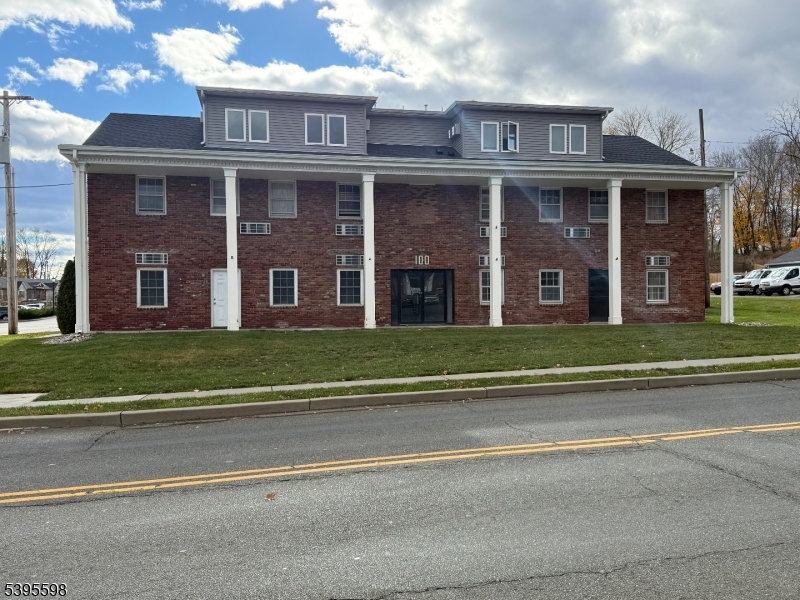 a view of a brick house next to a yard