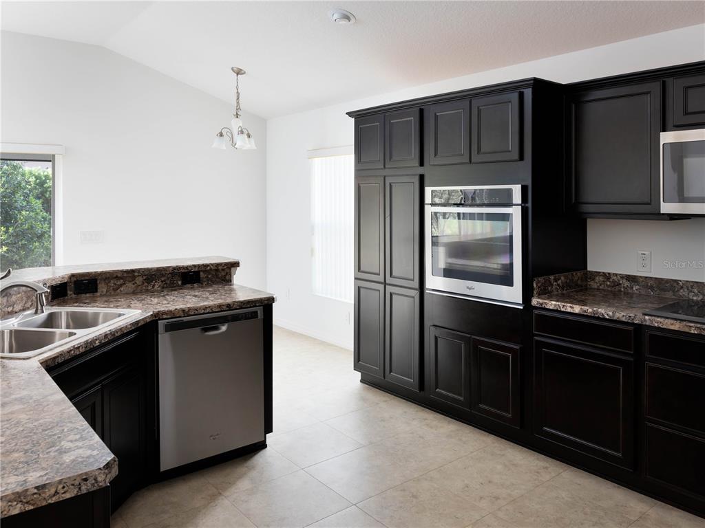 3942 Zenith Loop The Villages, FL 32163 - Photo 14 of 31 a kitchen with a sink stove and refrigerator