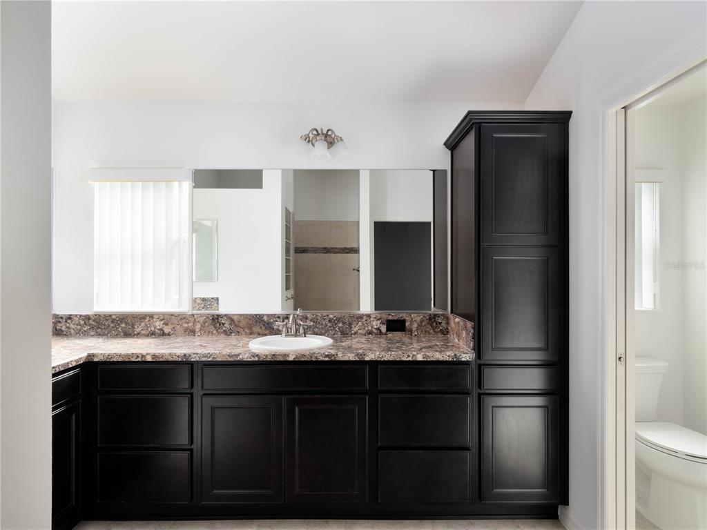3942 Zenith Loop The Villages, FL 32163 - Photo 20 of 31 a bathroom with a granite countertop sink and a mirror