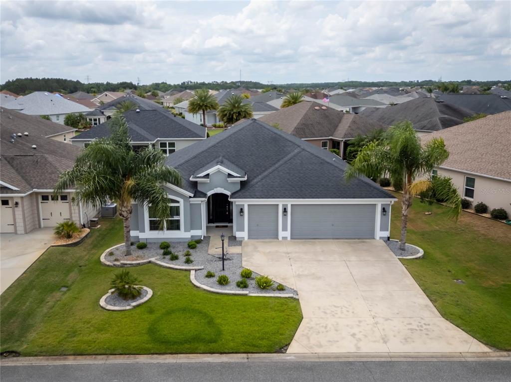 3942 Zenith Loop The Villages, FL 32163 - Photo 2 of 31 an aerial view of a house with yard swimming pool and mountain view in back