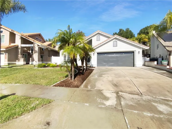 a view of a house with a yard and palm trees