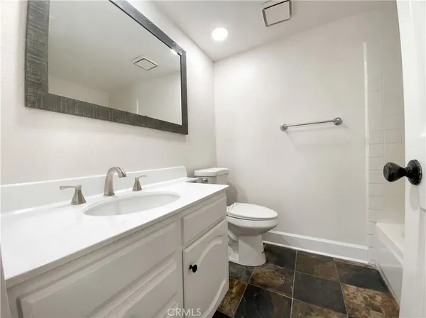 a bathroom with a sink mirror vanity and toilet