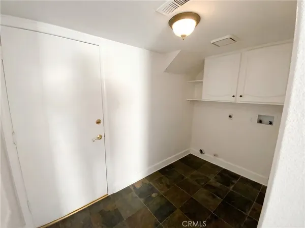 a view of a room with wooden floor and cabinets