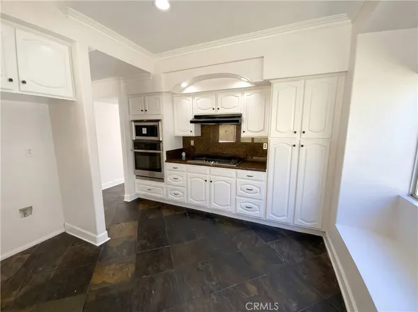 a kitchen with granite countertop a sink a microwave and cabinets