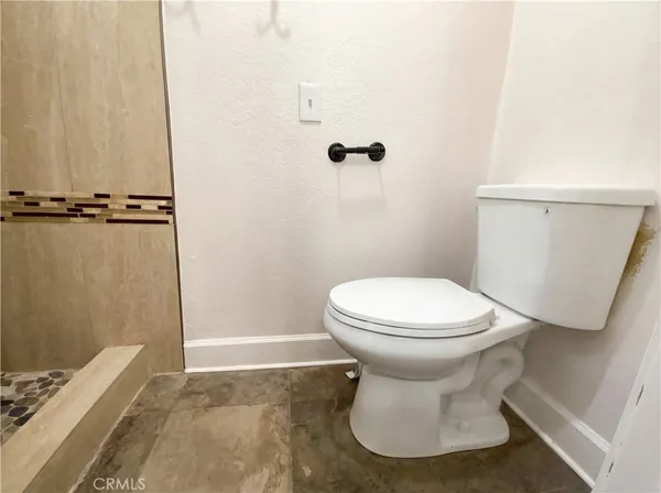 a bathroom with a toilet and a shower