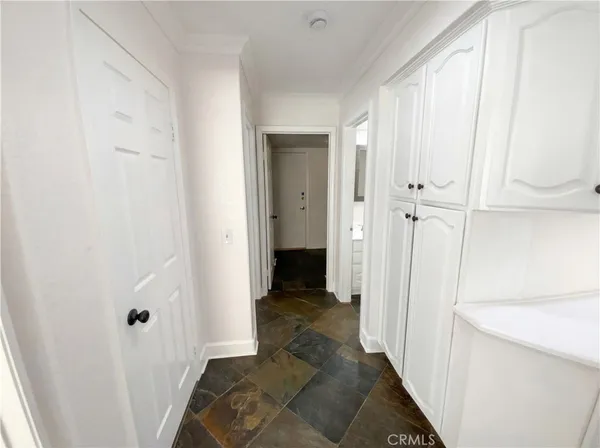 a view of a hallway with wooden floor and closet