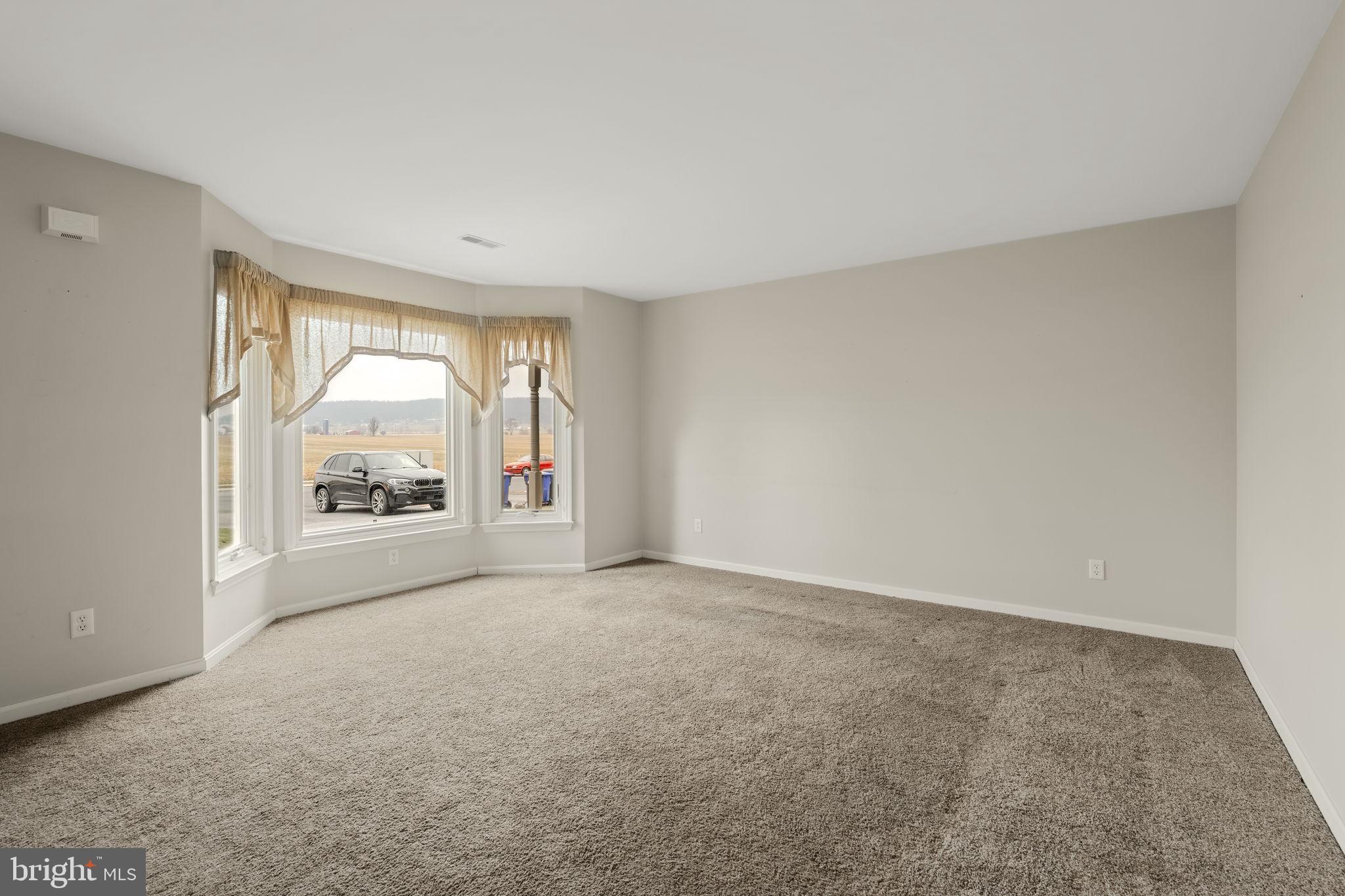 136 Bridle Path New Holland, PA 17557 - Photo 3 of 38 an empty room with a fireplace and large window