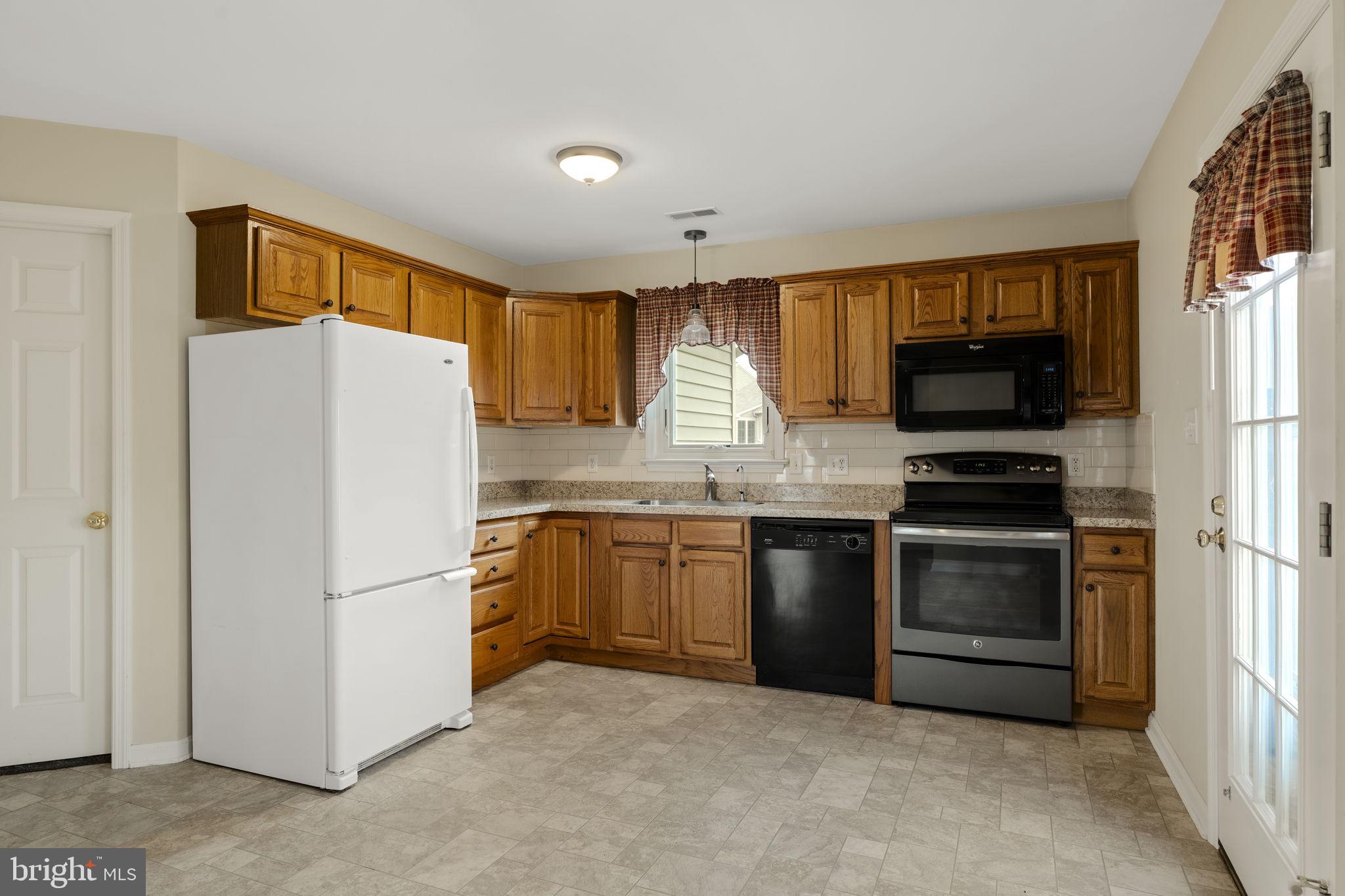 136 Bridle Path New Holland, PA 17557 - Photo 7 of 38 a kitchen with granite countertop a refrigerator stove top oven a sink and dishwasher