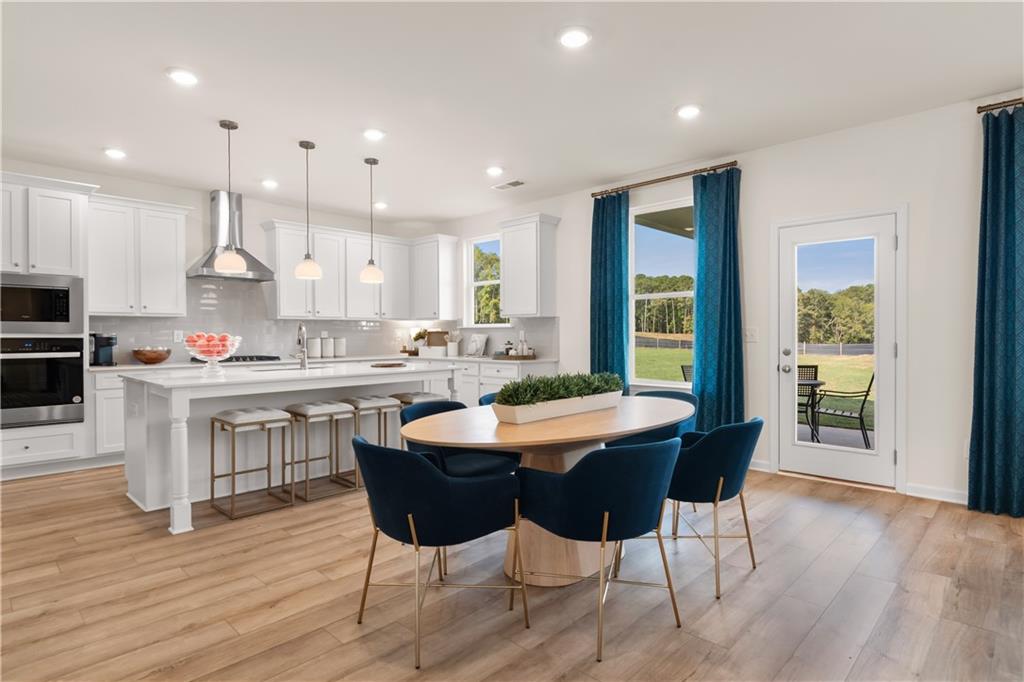 200 Chiswick Loop Stockbridge, GA 30281 - Photo 14 of 44 a kitchen with kitchen island granite countertop wooden floors and center island