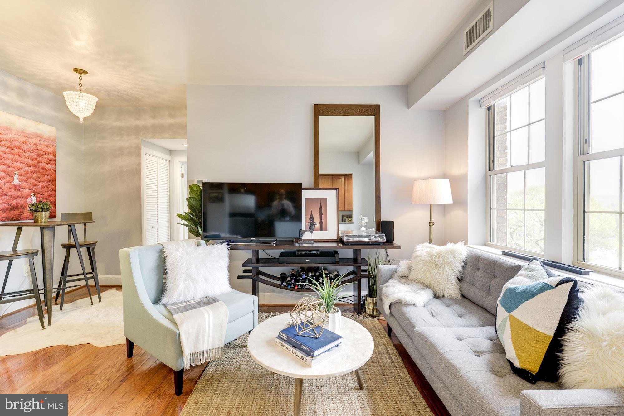 a living room with furniture a flat screen tv and a large window
