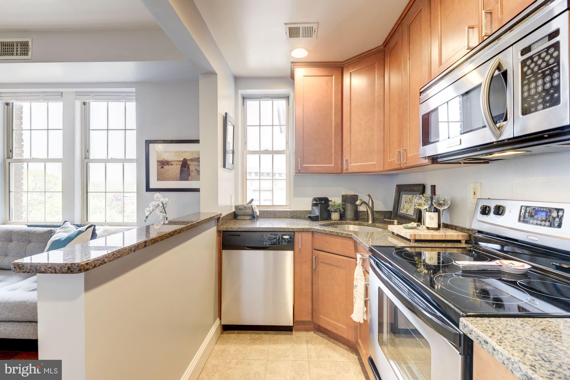 1673 Park Road Northwest, Unit 505 Washington, DC 20010 - Photo 4 of 17 a kitchen with stainless steel appliances granite countertop a sink stove and cabinets