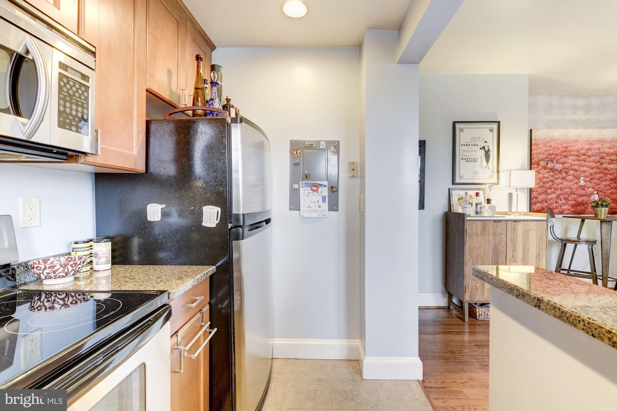 1673 Park Road Northwest, Unit 505 Washington, DC 20010 - Photo 5 of 17 a kitchen with granite countertop a sink stove and cabinets