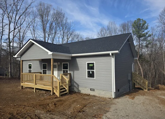 a view of a house with a yard and wooden fence