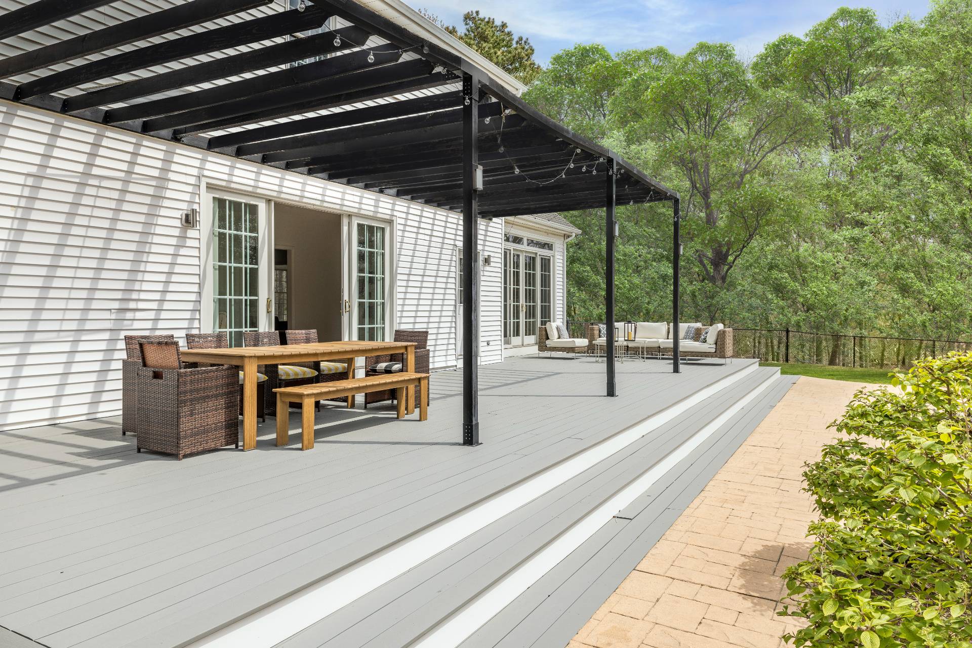 28 Quail Run Hampton Bays, NY 11946 - Photo 4 of 22 a view of a patio with table and chairs with wooden floor and fence