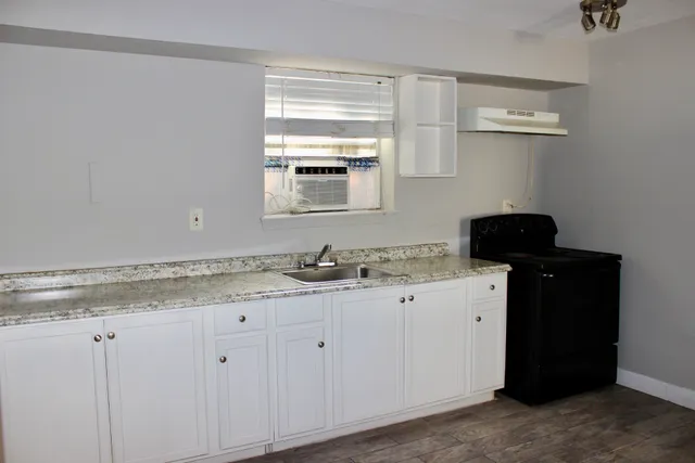 a bathroom with a granite countertop sink and a vanity