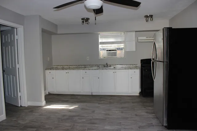 a view of a kitchen with a refrigerator and a sink