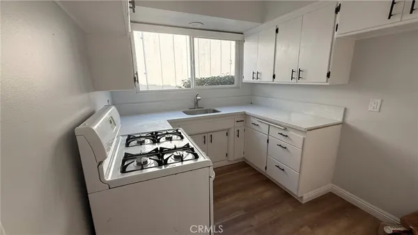 a kitchen with sink a stove and cabinets