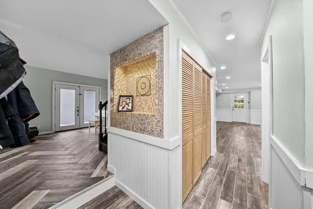 a view of a hallway with wooden floor and staircase