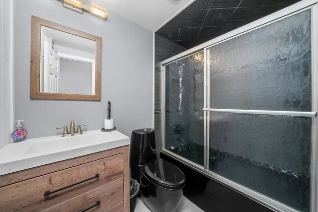 a bathroom with a sink a toilet and shower