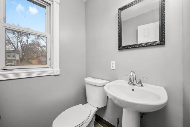 a bathroom with a toilet a sink and a mirror