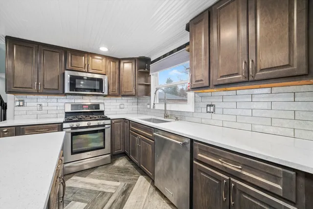 a kitchen with granite countertop stainless steel appliances and cabinets