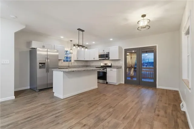 a kitchen with stainless steel appliances granite countertop a refrigerator a stove top oven a sink and dishwasher