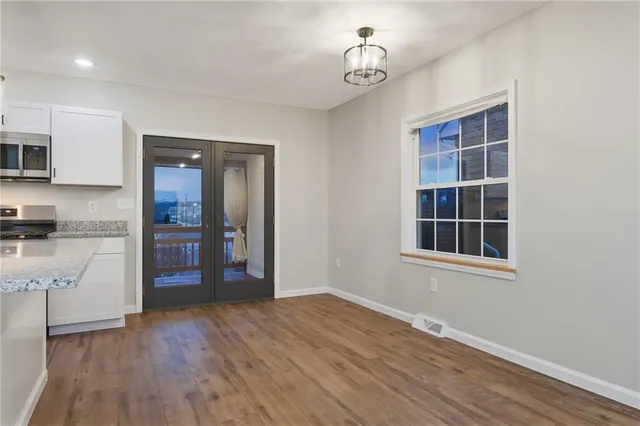 an empty room with wooden floor and cabinet