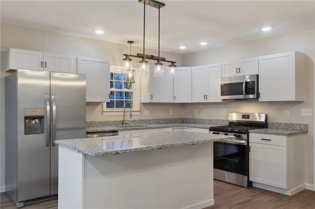 612 Virginia Avenue Rochester, PA 15074 - Photo 15 of 36 a kitchen with stainless steel appliances granite countertop a refrigerator a sink a stove a microwave and wooden floor