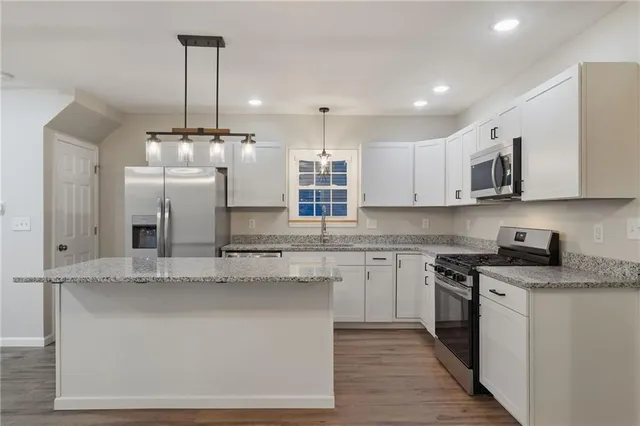 a kitchen with stainless steel appliances granite countertop a stove a sink and a refrigerator