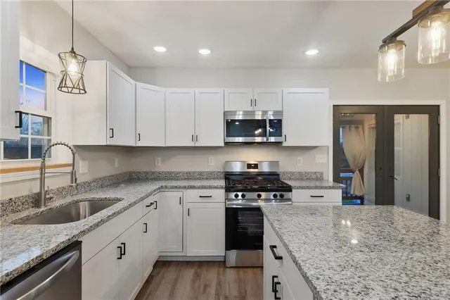 a kitchen with stainless steel appliances granite countertop a sink stove and refrigerator