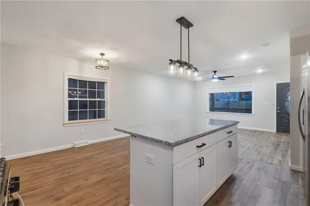 a kitchen with stainless steel appliances a stove refrigerator and wooden floor