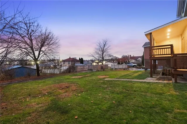 a view of a house with a big yard and a large tree