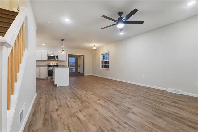 a view of kitchen with cabinets appliances and wooden floor