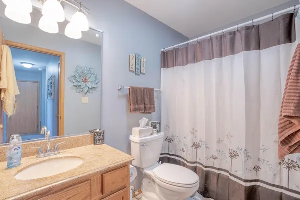a bathroom with a sink a toilet and shower curtain