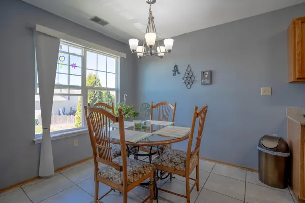 a view of a dining room with furniture a chandelier and window