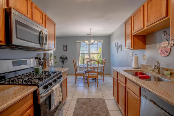 a kitchen with stainless steel appliances granite countertop a stove top oven a sink dishwasher and cabinets with wooden floor