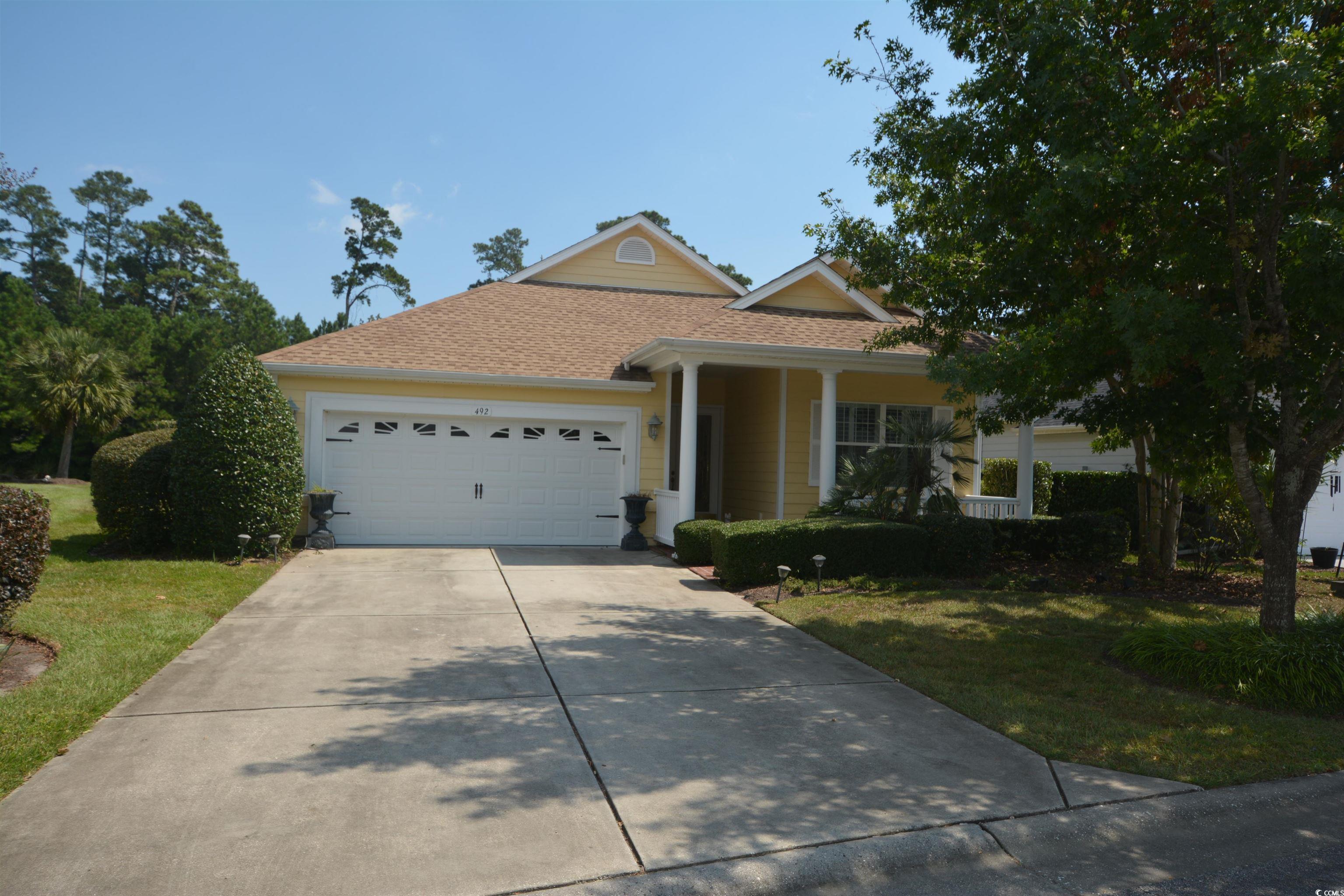 Single story home featuring a shingled roof, an attached garage, concrete driveway, and a front yard