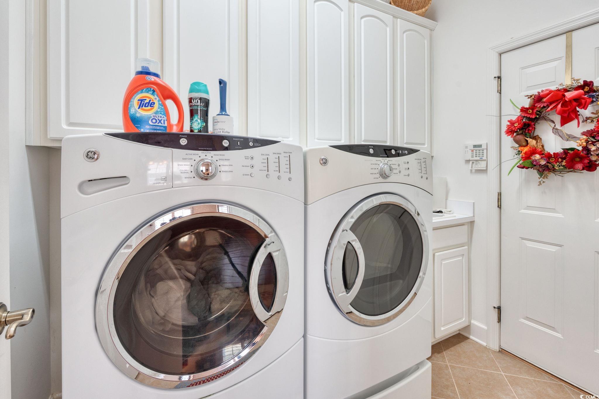 492 Grand Cypress Way Murrells Inlet, SC 29576 - Photo 13 of 40 Laundry room featuring washing machine and dryer, cabinet space, and light tile patterned flooring