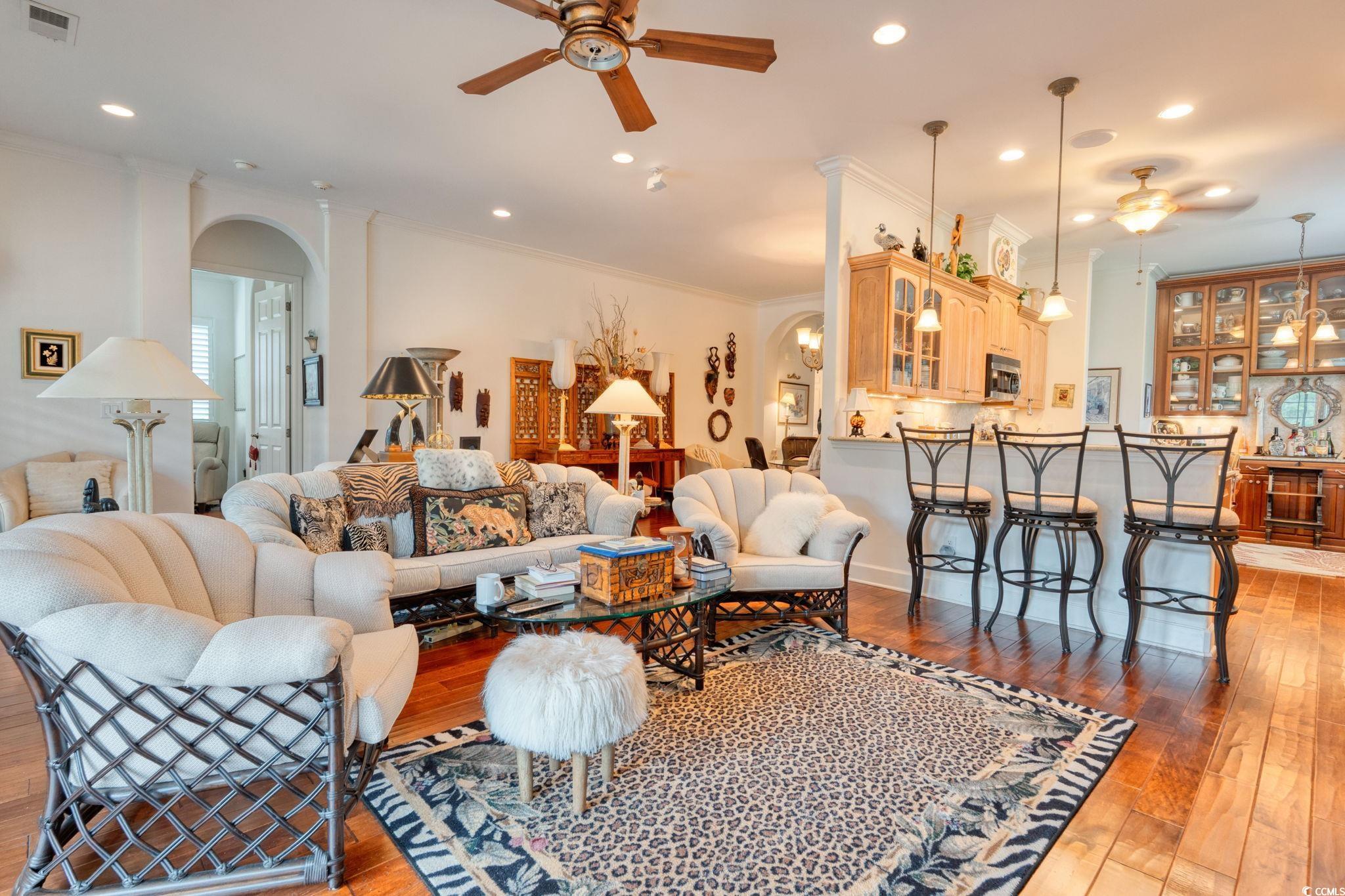 492 Grand Cypress Way Murrells Inlet, SC 29576 - Photo 14 of 40 Living area with arched walkways, a ceiling fan, light wood finished floors, crown molding, and recessed lighting