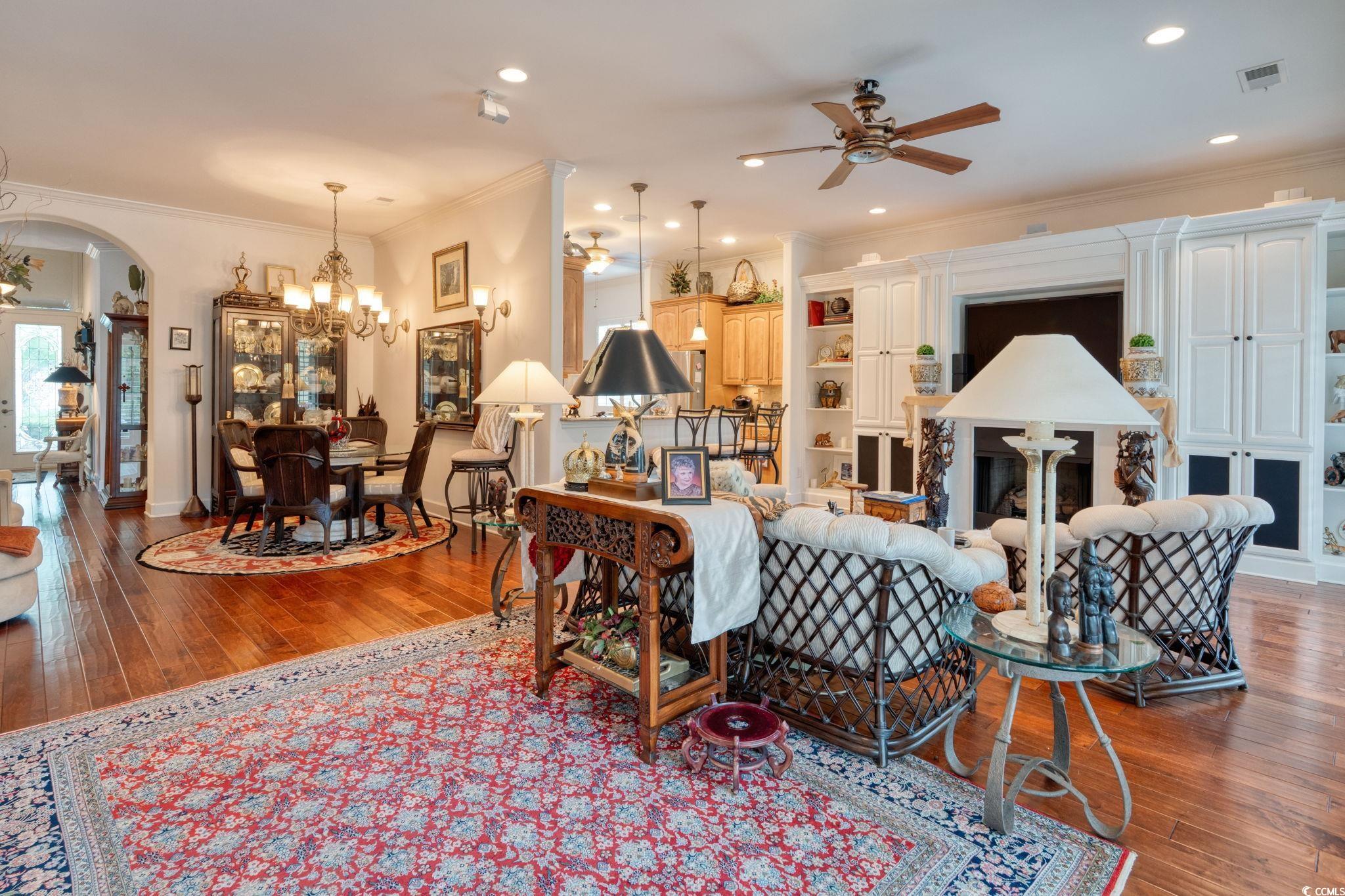 492 Grand Cypress Way Murrells Inlet, SC 29576 - Photo 6 of 40 Living room featuring ceiling fan, arched walkways, a chandelier, ornamental molding, and hardwood / wood-style flooring