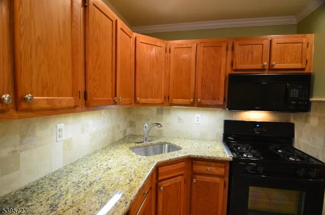 a kitchen with granite countertop wooden cabinets and a stove top oven