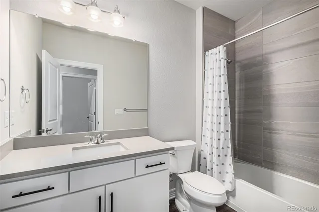 a bathroom with a sink toilet vanity and shower