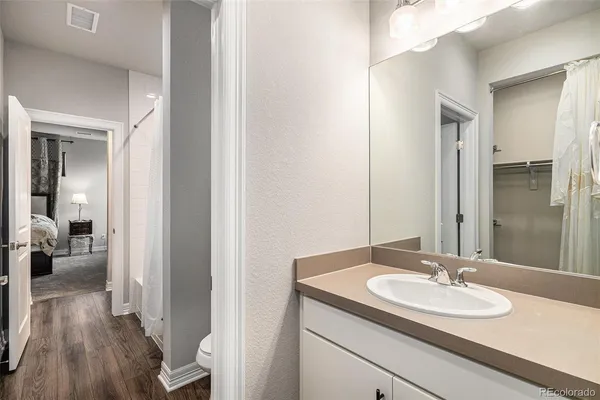 a bathroom with a granite countertop sink a mirror and vanity