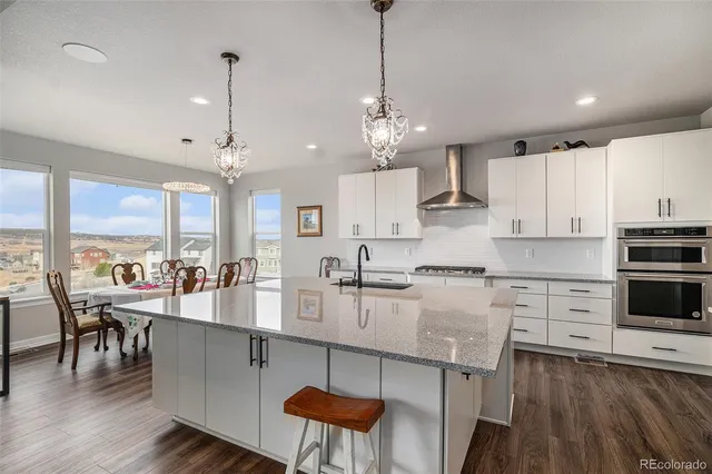 a large kitchen with lots of counter space and dining table