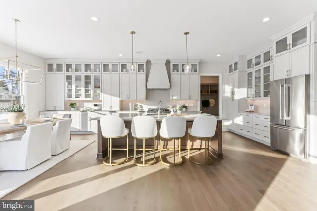 a large dining hall with stainless steel appliances kitchen island granite countertop a large cabinets and a dining table