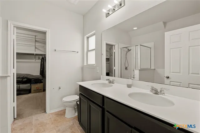 a bathroom with a double vanity sink toilet and shower